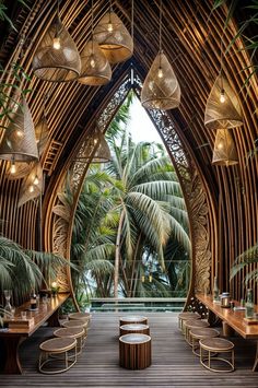 the inside of a restaurant with wooden tables and chairs, palm trees in the background