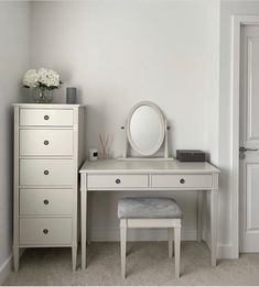 a white desk with a mirror and stool