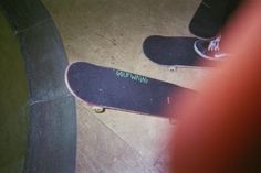 two skateboarders are standing on their boards