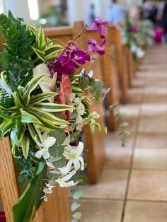 flowers and greenery decorate the pews of a church