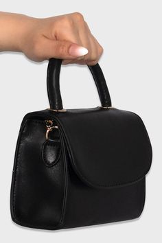 This classic mini purse is adored by customers! Includes a rolled top handle, matching crossbody strap, and fold over flap with a magnetic snap. Rolled top handle with 3" drop Removable & adjustable shoulder strap - maximum 25" drop 2 Interior pockets: 1 zippered / 1 slip Measurements: 7" L x 2.75" W x 5.25" H Gold tone hardware Vegan leather Also available in Nude Trendy Flap Shoulder Bag With Fold Over Clasp, Black Flap Bag With Top Carry Handle, Chic Bags With Detachable Adjustable Strap, Trendy Shoulder Bag Satchel With Fold-over Clasp, Trendy Shoulder Satchel With Fold Over Clasp, On-the-go Satchel With Double Handle And Magnetic Closure, Trendy Satchel Flap Bag With Fold Over Clasp, Chic Black Flap Bag With Fold Over Clasp, Everyday Bag With Magnetic Closure And Round Handle