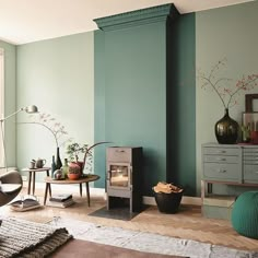 a living room filled with furniture and a fire place next to a wall painted in teal