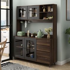 a wooden cabinet with glass doors and shelves in a room next to a dining table