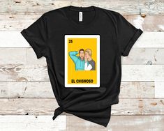 Make a bold statement with the "Loteria El Chismoso" T-shirt. This funny shirt is sure to turn heads and spark conversation wherever you go. Don't miss out on the opportunity to add some humor to your wardrobe. Get your hands on this must-have tee today! All Sales are Final.  The Unisex Jersey Short Sleeve Tee features a crew neck and tailored fit. Crafted from incredibly soft, proprietary Airlume combed and ring-spun cotton, the Unisex Jersey Short Sleeve Tee is a daily essential built for comfort, with a smooth surface perfect for printing of any kind.   Features: Side-seamed. Classic fit. Unisex sizing. Shoulder taping. Fabrication: 100% Airlume combed and ring-spun cotton, 32 singles, 4.2 oz. Sizes: S-4 XL HOW TO ORDER 1.- Check the size chart scrolling to the pictures.        SHIPPING Loteria Shirts, Nov 1, San Antonio Tx, Funny Shirt, San Antonio, Shoulder Taping, Funny Shirts, Jersey Shorts, Hands On