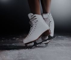 a pair of white ice skates with brown laces