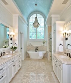 a large bathroom with two sinks and a tub