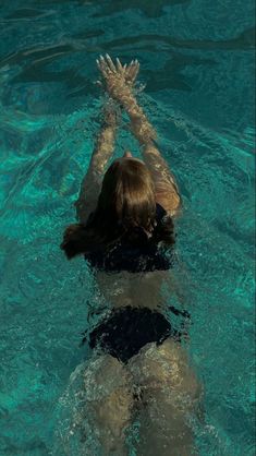 a woman swimming in the water with her arms outstretched