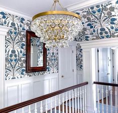 a chandelier hanging from the ceiling in a room with blue and white wallpaper