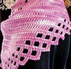 a woman wearing a pink knitted shawl on top of a mannequin