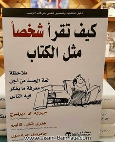 a sign with arabic writing on it in front of stacks of folded books at a store