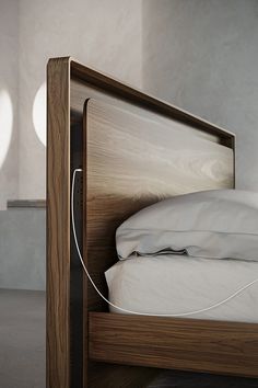 a wooden bed with white sheets and pillows