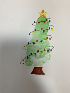 a child's drawing of a green christmas tree with lights on it and a star hanging from the top