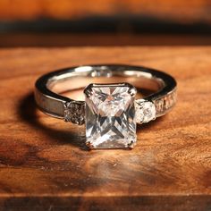 a diamond ring sitting on top of a wooden table