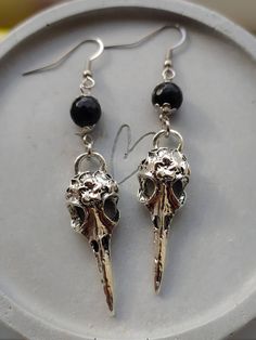 Stunning gothic style raven skull and black obsidian gemstone earrings in silver.  Earwires are made of stainless steel so are hypoallergenic. Skull pendants are made of zinc alloy. Black beads are real obsidian gemstone beads. Sold as a pair.  Please don't hesitate to contact me with any queries or suggestions 😊  Comes gift wrapped 🖤 Gothic Skull Earrings, Black Skull Earrings For Gift, Black Skull Sterling Silver Jewelry, Black Sterling Silver Skull Jewelry, Black Metal Witchy Earrings, Gothic Skull Shaped Pierced Earrings, Nickel Free Black Skull Earrings, Handmade Black Gothic Earrings, Handmade Black Skull Earrings