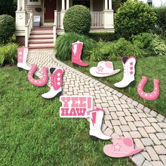 pink cowboy hats and boots yard decorations in front of a house