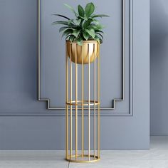 a gold plant stand with a potted plant in it