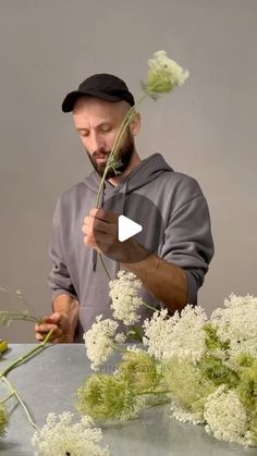 a man is arranging flowers on a table with the video showing him how to arrange them