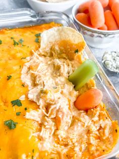 a casserole dish with carrots, celery and chicken