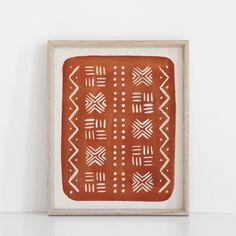 an orange and white painting on a wall next to a wooden frame with geometric designs