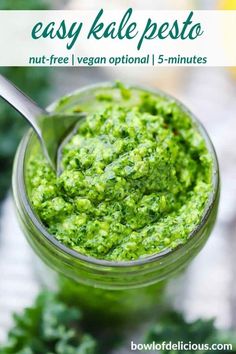 a jar filled with pesto next to some parsley