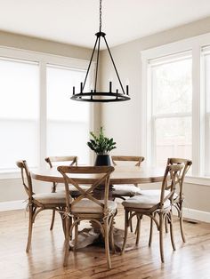 a dining room table with six chairs and a potted plant on top of it