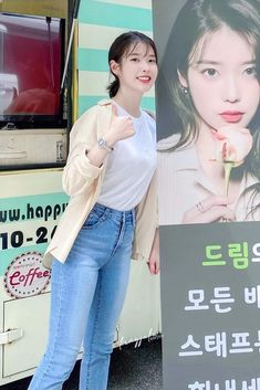 a woman standing next to a bus holding a rose