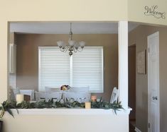 the dining room table is set with candles and greenery for an elegant centerpiece