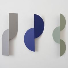 three different colored shapes on a white wall