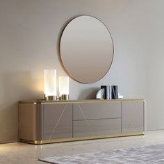 a large round mirror sitting on top of a dresser next to a table with candles