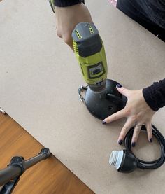 a person using a cordless sander on the floor next to a power drill