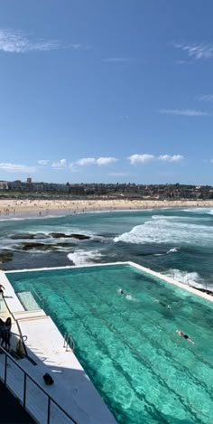 an outdoor swimming pool with people in the water