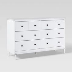 a white dresser with six drawers and two doors