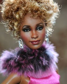 a close up of a barbie doll wearing a pink dress and fur collar with earrings