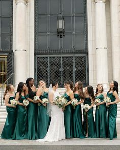 a group of women standing next to each other in front of a building with columns