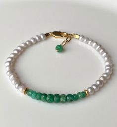 "Bracelet made of Zambian Emerald hand faceted rondelles and natural cream white freshwater Pearls. The vibrant green Emeralds have been graduated in size and color and they offer a beautiful contrast to the cream white Pearls. With 2 pcs of 22k gold vermeil spacer beads and 14k gold filled lobster clasp and textured extension chain. Length of the bracelet is 17 cm (6.7\") and length of the extension chain is 2 cm (0.8\"), so it will fit a wrist up to 19 cm (7.5\"). Please let us know if you nee Cheap Adjustable Green Pearl Bracelet, Elegant Rondelle Pearl Bracelet With Gemstone Beads, Elegant Green Pearl Bracelet With Natural Stones, Elegant Green Pearl Hand-strung Bracelet, Elegant Green Hand-strung Pearl Bracelet, Elegant May Birthstone Beaded Bracelets With Faceted Beads, Elegant May Birthstone Faceted Beaded Bracelets, Elegant Hand-strung May Birthstone Beaded Bracelets, White Rondelle Pearl Bracelet