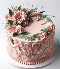 a pink cake decorated with flowers and pearls