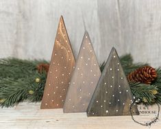 three wooden christmas trees sitting on top of a table