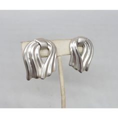 This is part of Chairish’s Costume Jewelry assortment.  1980s Modernist rhodium plated wavy ribbon clip earrings. Marked "Monet©." Measure: 1 3/8 inches long by 1 1/8 inches wide. Condition: Very good; minor wear. The matching necklace is also available. Retro Silver Metal Clip-on Earrings, Silver Retro Metal Clip-on Earrings, Silver Retro Clip-on Earrings For Evening, Ribbon Clip, Diamond Dangle Earrings, Art Deco Earrings, Diamond Drops, Accessories Jewelry Earrings, Modern Earrings