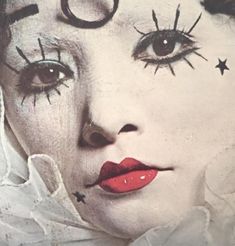 a close up of a person with makeup on and stars painted on their face,