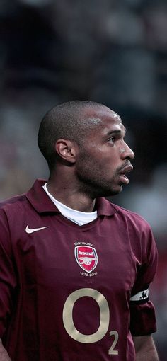 a close up of a soccer player wearing a maroon uniform with the number 0 on it