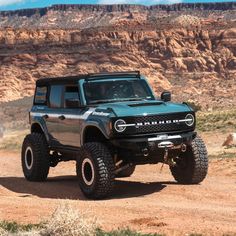 a blue truck driving down a dirt road