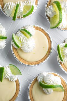 several small pies with lime and whipped cream on them