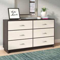 a dresser with drawers and a mirror on top of it in a room next to a blue rug