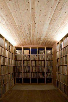 a room filled with lots of wooden shelves and bookshelves covered in vinyl records