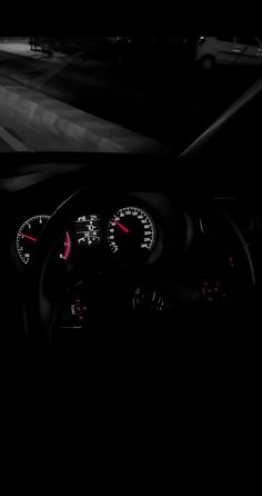 the interior of a car with dashboard lights and gauges in black and white photo