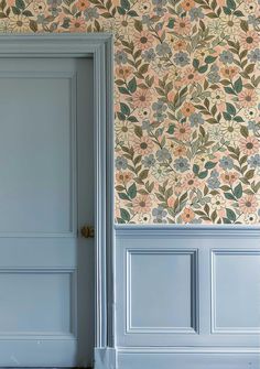 an open door in front of a wallpapered room with flowers on the walls