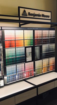 a display case filled with lots of different colored paint swatches in front of a sign