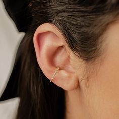 This ear cuff is made from 18 karat gold-plated sterling silver and consists of a single band with squared edges, half covered with tiny white zircon stones embellishing the outer surface. It has a small gap in the band where it fits onto the ear, and two metallic balls on either side of the gap to hold it securely in place. Simple yet sophisticated, this is a versatile piece that will add the perfect amount of extra sparkle to an outfit.  DETAILS: Diameter: Outer diameter: 1.4 cm Weight: 1.0 g Material: 18 k gold plated, 925 Sterling Silver 🏷️ This product is made of sterling silver -- easily recognizable by its '925' stamp of authenticity. It is also hypoallergenic, making it suitable for people with sensitive or irritable skin. We recommend avoiding perfume, deodorant or other chemical Gold Plated Single Ear Cuff Fine Jewelry, Dainty Yellow Gold Ear Cuff For Everyday, Fine Jewelry Gold Ear Cuff As Gift, Gold Dainty Ear Cuff For Anniversary, Fine Jewelry Yellow Gold Single Ear Cuff, Gold Fine Jewelry Ear Cuff Gift, Yellow Gold Sterling Silver Huggie Ear Cuff, Dainty Gold Ear Cuff For Anniversary, Pierced Yellow Gold Ear Cuff For Anniversary