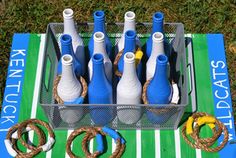 several blue and white bottles sitting in a metal container on top of a green field