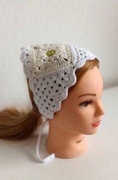 a mannequin head wearing a white crochet hat